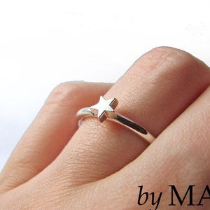 Könnte beinhalten: Ein silberner Ring mit einem kleinen, erhabenen Sternmuster. Der Ring wird an einem Finger getragen. Der Text "by MAJ" ist in der unteren rechten Ecke des Bildes sichtbar.
