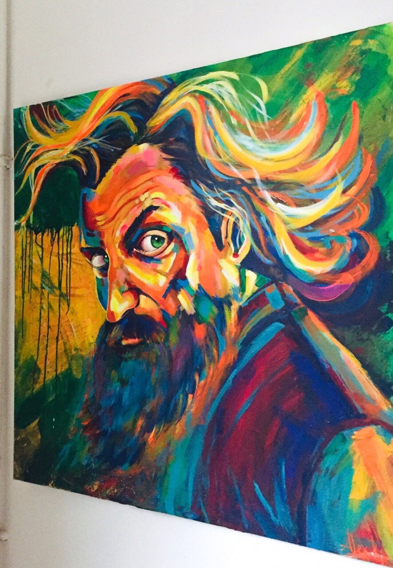 May include: A colorful abstract painting of a man with long, flowing hair and a beard. The painting is done in a variety of bright colors, including red, orange, yellow, green, blue, and purple. The man's face is partially obscured by his hair, but his piercing green eye is visible. The background of the painting is a dark green.
