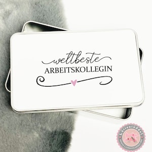 Könnte beinhalten: Eine weiße Metalldose mit dem Text "weltbeste ARBEITSKOLLEGIN" und einem kleinen rosa Herz.