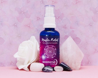 Puede incluir: Una botella de vidrio azul con un pulverizador blanco y una etiqueta que dice "Master Protect Trust, protection & sensitivity MOONSTAR energies". La botella está rodeada de cristales blancos y rosados.