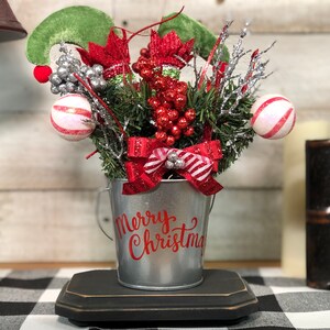 Elf Dives Into Christmas. Metal bucket with Christmas Floral and Red Bows featuring Elf Legs. Whimsical Christmas Rustic Holiday Decor