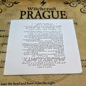 May include: A white card with black text and symbols. The text reads "Witchcraft Prague" and includes a series of symbols and letters. The text at the bottom reads "near the bowl and leave it for the night."