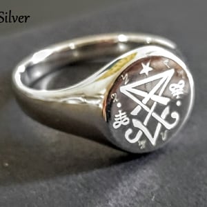 May include: A silver signet ring with an engraved design. The ring is made of 925 silver.