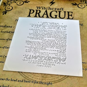 May include: A white card with black text that reads "Witchcraft Prague" and a series of symbols and letters. The text is in a gothic font.