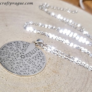 May include: A silver necklace with a round pendant featuring a Star of David and Hebrew text. The pendant is inscribed with the words "הזי ח כוס מפלה חהו すすす ロクレ הוה ענו עלם מהם ללה אכא כהה 115, פהל נלך ל 4 חבו אלד לאו ההע יול כבה הרי אין ההה מ נתה האא ירת שאה ריי ';לה קאל ערה חעם רהע 「「א נית מבה פוינלי אני דמן ard aq מיך כמה איע הוילי uda סיט ווסו דני"