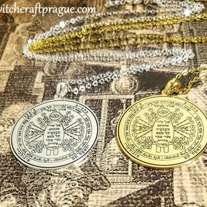 May include: Two circular pendants with intricate designs and text. One is silver-toned, the other gold-toned, both hanging on delicate chains. The pendants feature detailed symbols and inscriptions, likely for spiritual or symbolic purposes.