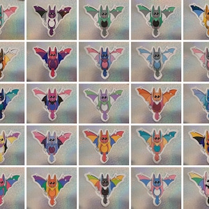 May include: Twenty-five bat stickers with different pride flag designs. Each sticker features a cartoon bat with a different pride flag design on its wings. The stickers are printed on white paper and have a glossy finish.