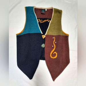 May include: A colorful, patchwork-style knitted vest. The vest features panels of teal, navy, olive green, and brown. It has a V-neck, two decorative buttons, and an embroidered design. The vest is a unique piece of clothing.