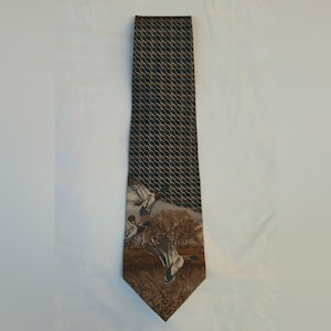 May include: A brown and black patterned necktie. The top portion features a repeating pattern, while the bottom has a nature scene with ducks. The tie is made of a smooth fabric and is suitable for formal or business attire.