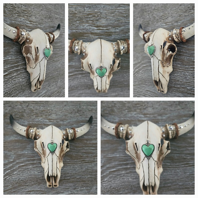 May include: Five white ceramic bull skulls with turquoise heart-shaped accents. Each skull has rhinestones and a beaded rope detail on the horns.