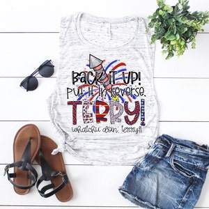 May include: A white and gray marble-patterned tank top with the text "Back It Up! Put it in reverse. Terry!" in red, white, and blue. The tank top is paired with denim shorts, black sandals, and sunglasses.