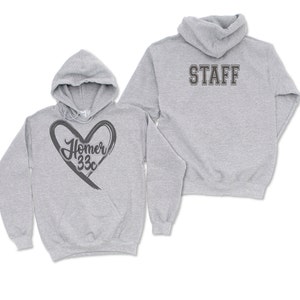 May include: Two light gray hoodies. One features a dark gray heart design with the text "Homer 33c". The other hoodie has "STAFF" printed on the back in a dark gray, block letter style. Both hoodies have a hood and a front pocket.