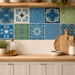May include: A kitchen backsplash featuring a grid of ten square tiles with diverse patterns in shades of blue, green, and cream. The tiles display intricate floral, geometric, and damask motifs, creating a decorative wall covering above a wooden counter.