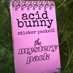 May include: Pink sticker pack labelled "acid bunny sticker pack:03 the mystery pack" with a border of question marks.