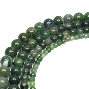 May include: A strand of green agate beads in various sizes. The beads are round and have a smooth, polished finish. The beads are arranged in a graduated pattern, with the largest beads at the top and the smallest beads at the bottom.