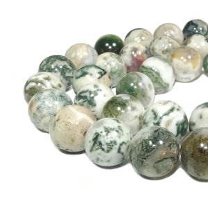 Può includere: Una collana di perle di agata verde, bianca e marrone. Le perle sono rotonde e hanno una finitura naturale e lucida.