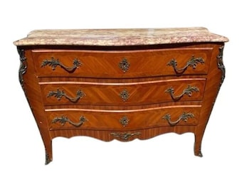 May include: A three-drawer antique chest of drawers with a marble top. The chest is made of wood with a marquetry design and has ornate brass hardware.