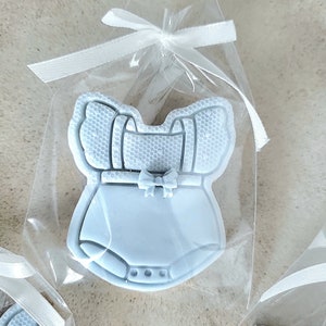 May include: A light blue baby onesie cookie in a clear cellophane bag tied with a white ribbon.
