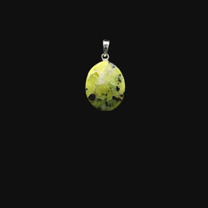Peut inclure: Un pendentif ovale avec une bélière en argent, composé d'une pierre naturelle verte et noire avec un motif unique.