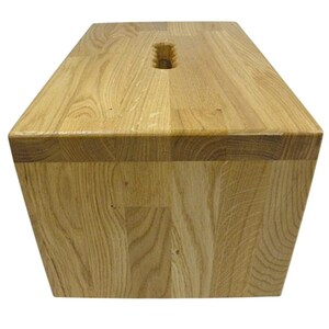 K&ouml;nnte beinhalten: Eine rechteckige Holzkiste in hellem Braun. Sie hat einen eingelassenen Griff auf der Oberseite und besteht aus mehreren Holzst&uuml;cken. Die Holzmaserung ist im gesamten Design sichtbar.