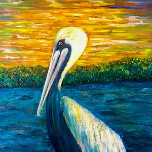 May include: A brown pelican with a long beak stands on a wooden post with metal rings. The pelican is facing to the right and has a blue, white, and yellow plumage. The background is a blue lake with green reeds and a yellow and orange sunset.