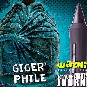 May include: A teal-colored Giger' Phile stylus holder with a detailed, textured design. The holder is shaped like an alien egg, with a stylized creature on the front. Two styluses are visible, one black and one white. The text "Wachibi Stylus Holders" is also visible.