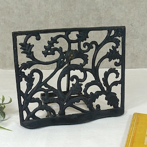Könnte beinhalten: Schwarzer Metall-Buchstütze mit einem dekorativen floralen Design. Der Buchstütze ist aus Gusseisen und hat einen Vintage-Look.