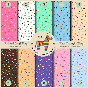Peut inclure: Dix feuilles de vinyle de couleurs différentes avec un motif de confettis. Les feuilles de vinyle sont numérotées de 1 à 10. Le texte "Printed Craft Vinyl" et "Oracal 631/651" est en haut de l'image. Le texte "Heat Transfer Vinyl" et "Siser HTV / Glitter HTV" est en haut de l'image. Une piñata en forme d'âne avec des rayures arc-en-ciel est au centre de l'image avec le texte "733" et "DONKEY CRAFT VINYL".