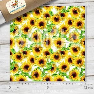 May include: A sheet of vinyl featuring a repeating pattern of yellow sunflowers with brown centers and green leaves on a white background. The sheet measures 12 inches wide. A roll of vinyl and a lid are in the image.