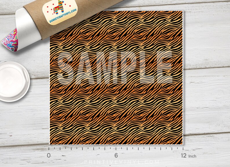 May include: A 12-inch by 12-inch sample of orange and black zebra print vinyl. The vinyl has a repeating pattern of wavy stripes.