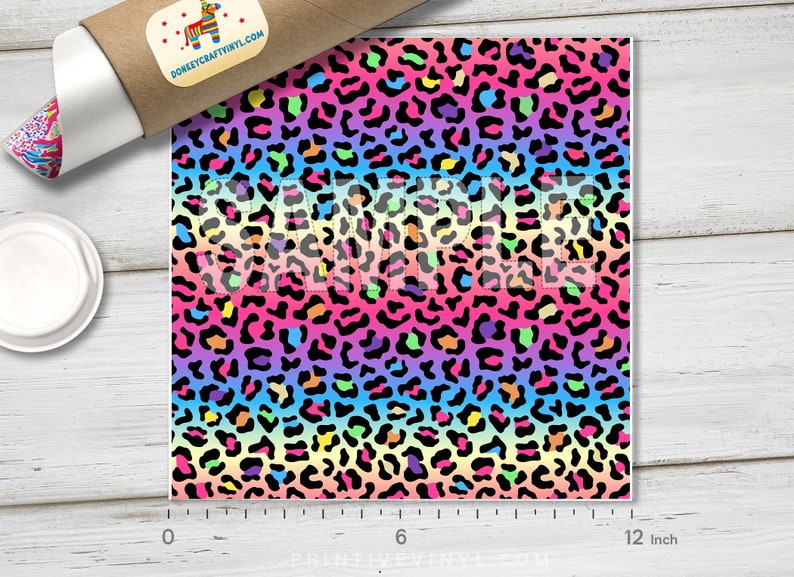 May include: Rainbow leopard print fabric with black spots on a gradient background of pink, orange, yellow, green, blue, and purple. The fabric is 12 inches wide.