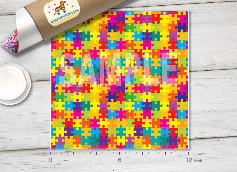 May include: A sample of colorful puzzle piece patterned vinyl, measuring 12 inches wide. The word "SAMPLE" is printed over the vinyl.