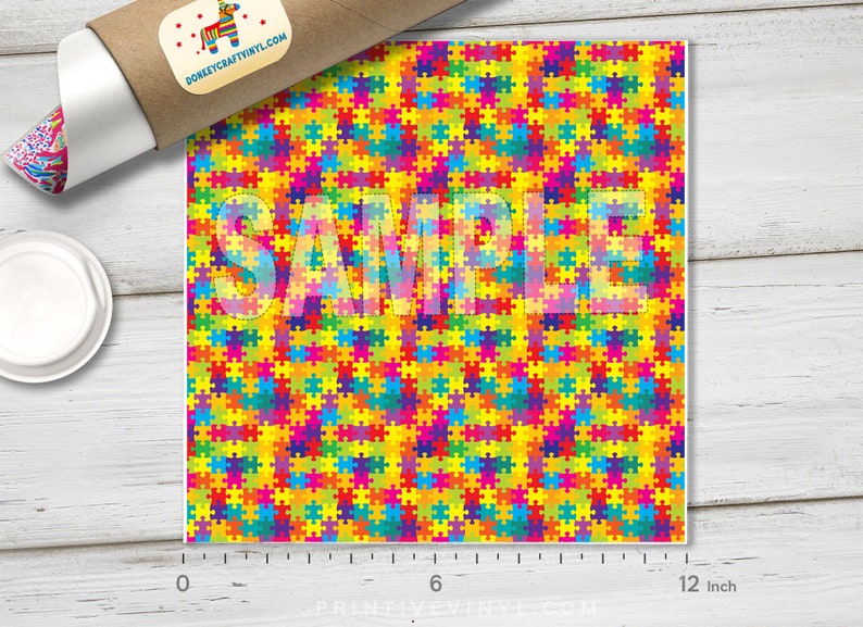 May include: A colorful puzzle piece pattern with a repeating design of red, orange, yellow, green, blue, purple, and pink puzzle pieces. The pattern is 12 inches wide.