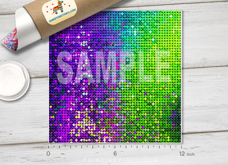May include: A square sheet of vinyl with a vibrant, shimmering pattern. The design transitions from purple to green, with the word "SAMPLE" overlaid. The sheet measures approximately 12 inches wide.
