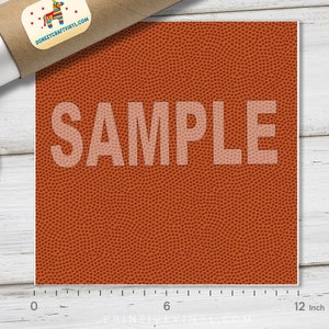 May include: A square sheet of orange vinyl with a basketball texture, measuring 12 inches across. The word "SAMPLE" is printed in a light color across the center. A rolled-up poster and a lid are in the background.