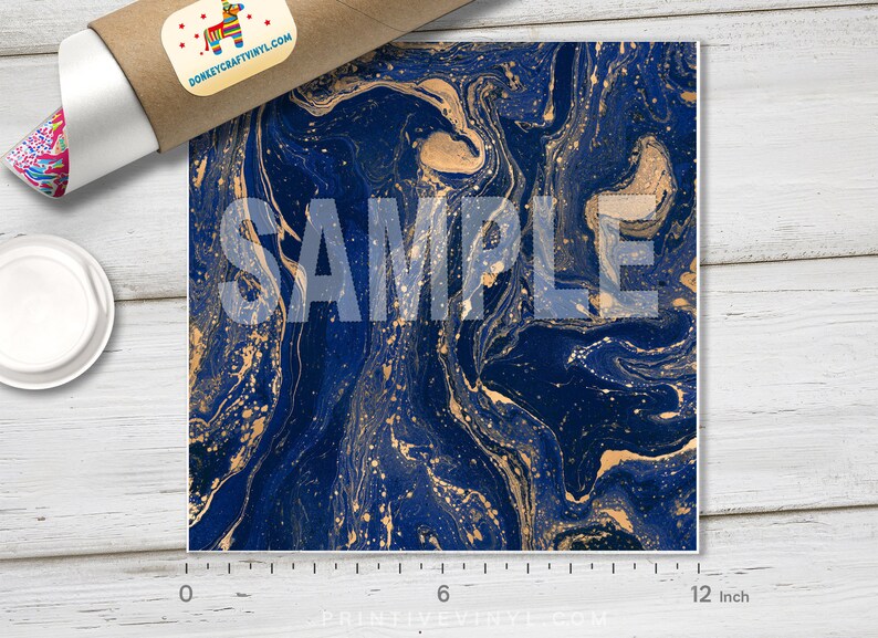 May include: A square sheet with a navy blue and gold marbled design. The pattern has swirling, fluid lines with gold accents. The word "SAMPLE" is printed across the center. The sheet measures 12 inches across.