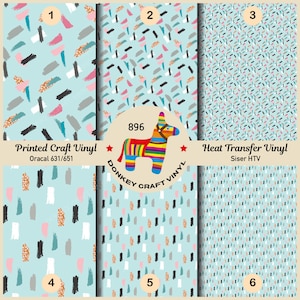 May include: A collection of six patterned vinyl sheets with abstract brushstroke designs in various colors, including black, gray, pink, and gold, on a light blue background. The image also features a colorful donkey piñata and text that reads "Printed Craft Vinyl" and "Heat Transfer Vinyl".