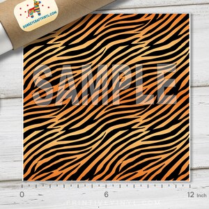 May include: A 12-inch by 12-inch sheet of orange and black tiger stripe vinyl. The vinyl has a gradient effect, with the orange being lighter at the top and darker at the bottom. The vinyl is marked "SAMPLE" in the center.