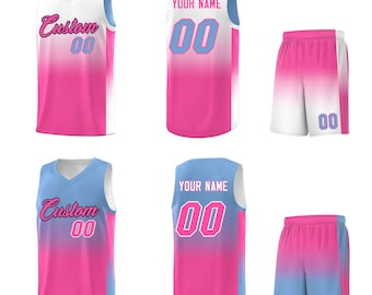 Puede incluir: Un conjunto de camisetas y pantalones cortos de baloncesto personalizados. Las camisetas son blancas, rosas y azules con la palabra "Custom" y el número "00" en la parte delantera. Los pantalones cortos son rosas y azules con el número "00". La parte trasera de las camisetas tiene el texto "YOUR NAME" y el número "00".