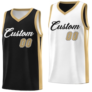 May include: Two basketball jerseys, one black with gold trim and one white with gold trim. Both jerseys have the word "Custom" and the number "00" printed on them.