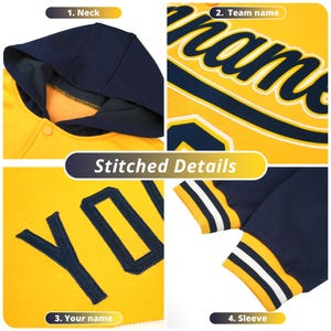 May include: A yellow and navy blue baseball jacket with a hood. The jacket has a snap closure and a ribbed collar, cuffs, and waistband. The jacket has a stitched detail on the front that says "YOU" and a stitched detail on the back that says "Team name".