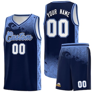 May include: A navy blue basketball jersey with a light blue and white wave pattern. The jersey has a white v-neck and the text "Custom 00" on the front. The back of the jersey has the text "Your Name 00". A matching pair of navy blue basketball shorts with a light blue and white wave pattern and the number "00" on the right leg.