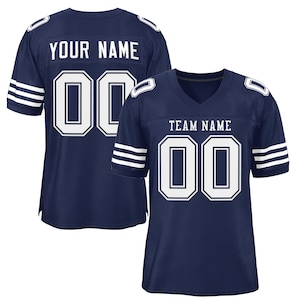 Op de afbeelding: Een donkerblauw voetbaltenue met witte strepen op de mouwen. Het tenue heeft een wit nummer "00" op de voor- en achterkant. De tekst "TEAM NAME" staat boven het nummer op de voorkant van het tenue. De tekst "YOUR NAME" staat boven het nummer op de achterkant van het tenue.