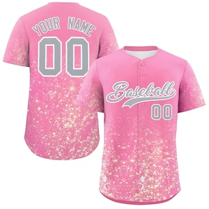 Könnte beinhalten: Rosa Baseball-Trikot mit dem Wort "Baseball" in Schreibschrift und der Nummer "00" in Grau. Auf der Rückseite des Trikots stehen die Worte "YOUR NAME" und die Nummer "00" in Grau. Das Trikot hat ein glitzerndes Design.