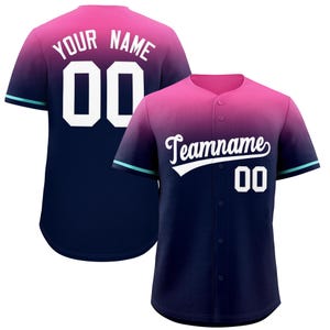 May include: A pink and navy blue baseball jersey with a gradient design. The jersey has a white number "00" on the back and the text "YOUR NAME" above it. The front of the jersey has the text "Teamname" in a white cursive font with a white number "00" below it.