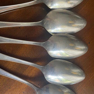 May include: Five silver spoons with the words "18/8 Stainless" stamped on the back of each spoon.