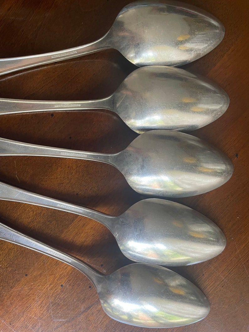 May include: Five silver spoons with the words "18/8 Stainless" stamped on the back of each spoon.