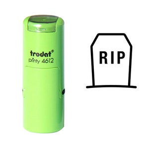 May include: Green self-inking stamp with the text "trodat printy 4612" and a black and white image of a tombstone with the text "RIP" on it.