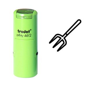 May include: A light green self-inking stamp with the text "trodat printy 4612" and a black outline of a pitchfork. The stamp is cylindrical with a clear top. The pitchfork is a simple, two-dimensional design.