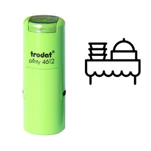 May include: A green self-inking stamp with the text "trodat printy 4612" and an icon of a table with a plate stack and a cloche on top.
